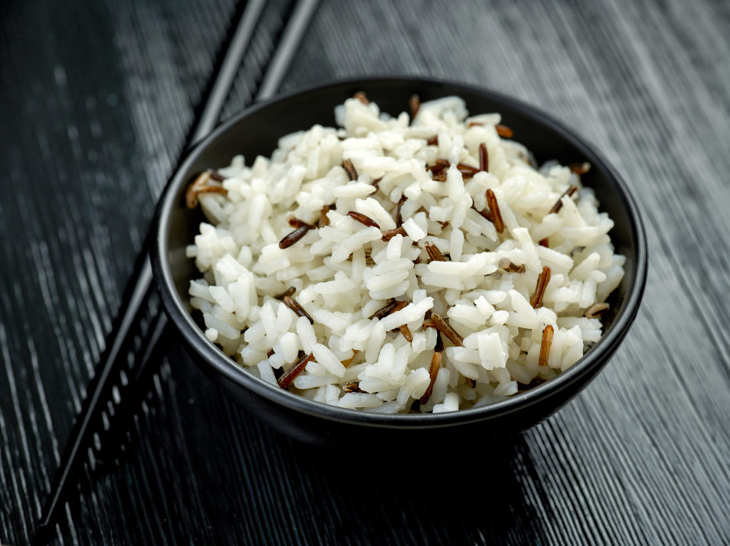 bowl of long grain and wild rice on black wooden table