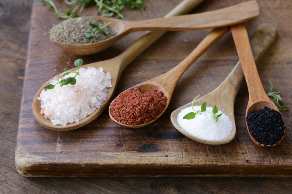 different varieties of salt in wooden spoons