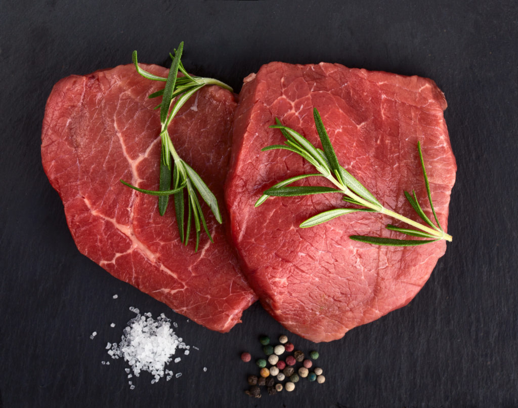 Fresh raw beef with rosemary on black background. Cooking the Perfect Steak