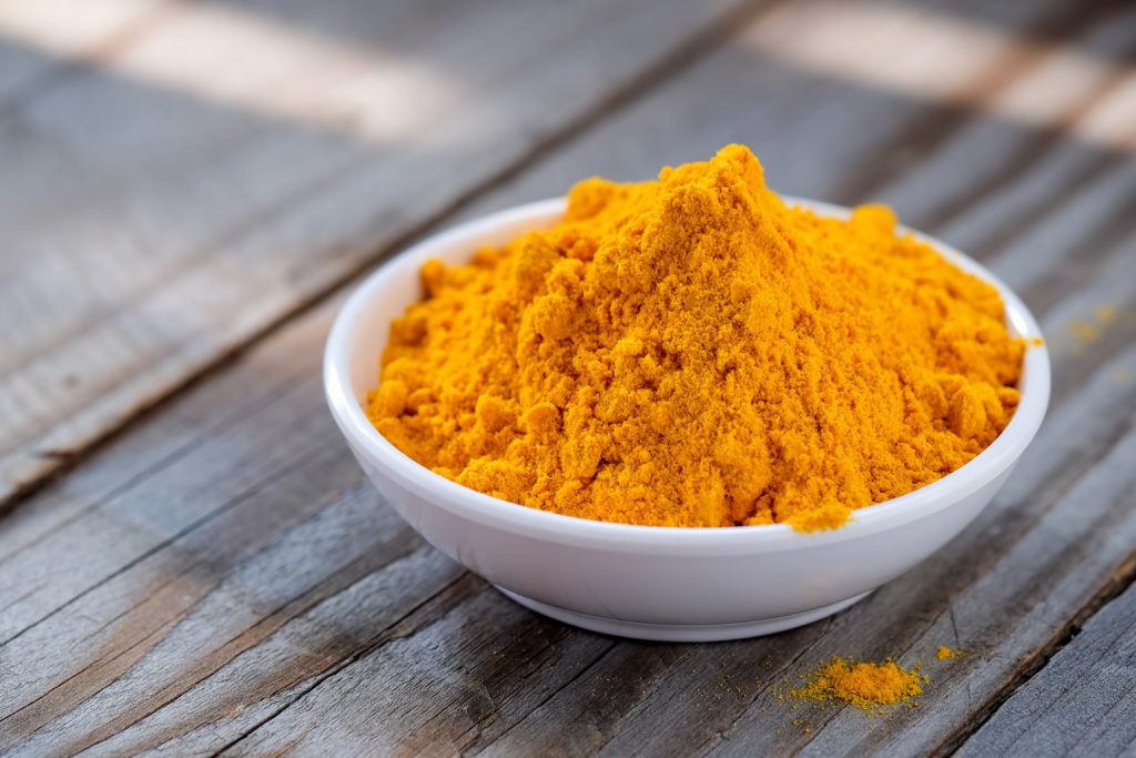 Turmeric powder in white cup.