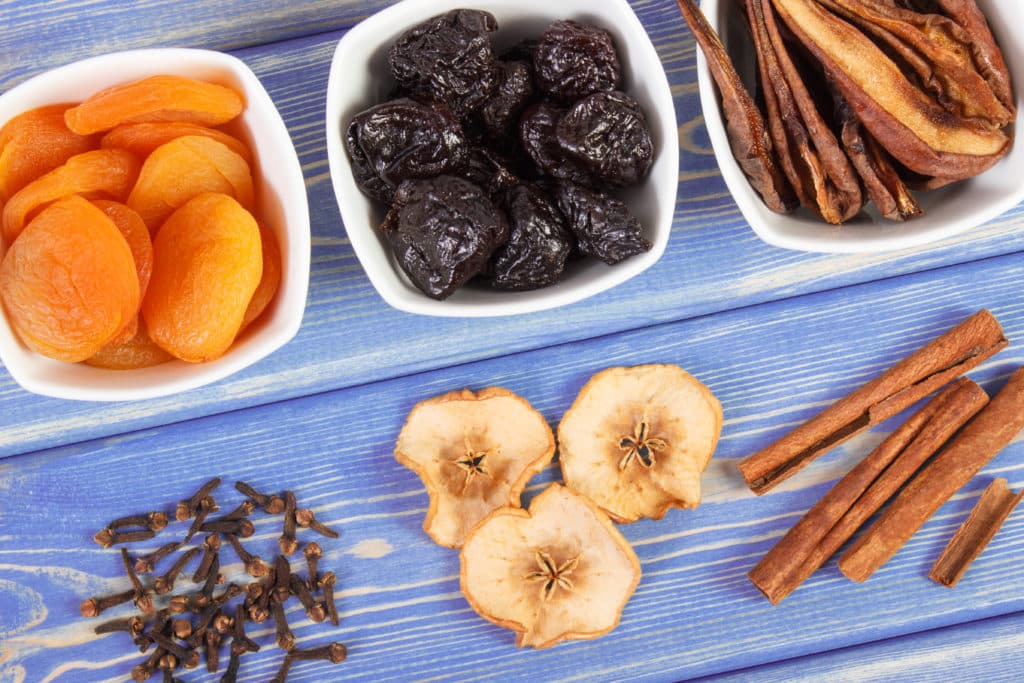 Dried ingredients and spices for preparing beverage or compote of dried fruits lying on wooden boards, healthy nutrition