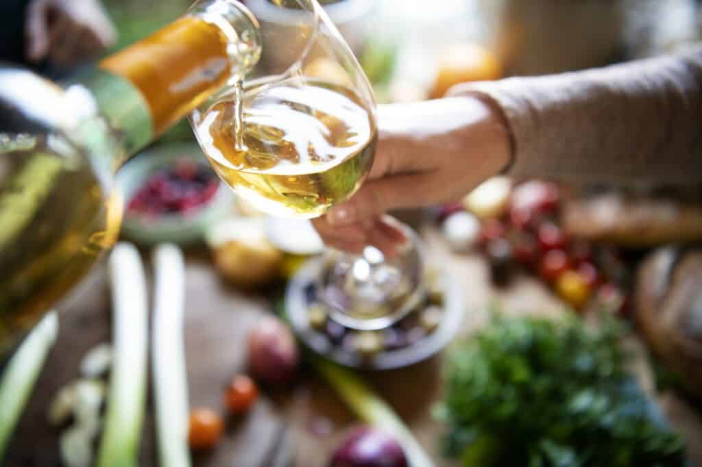 Couple having white wine while cooking