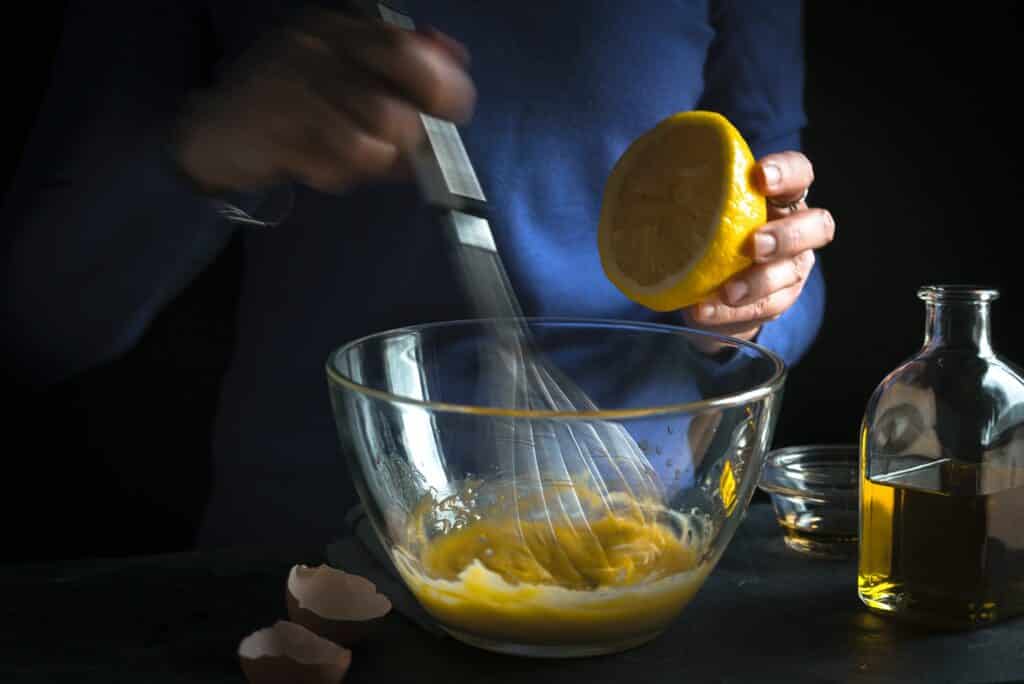 Whipping yolk with mustard and squeezing lemon juice